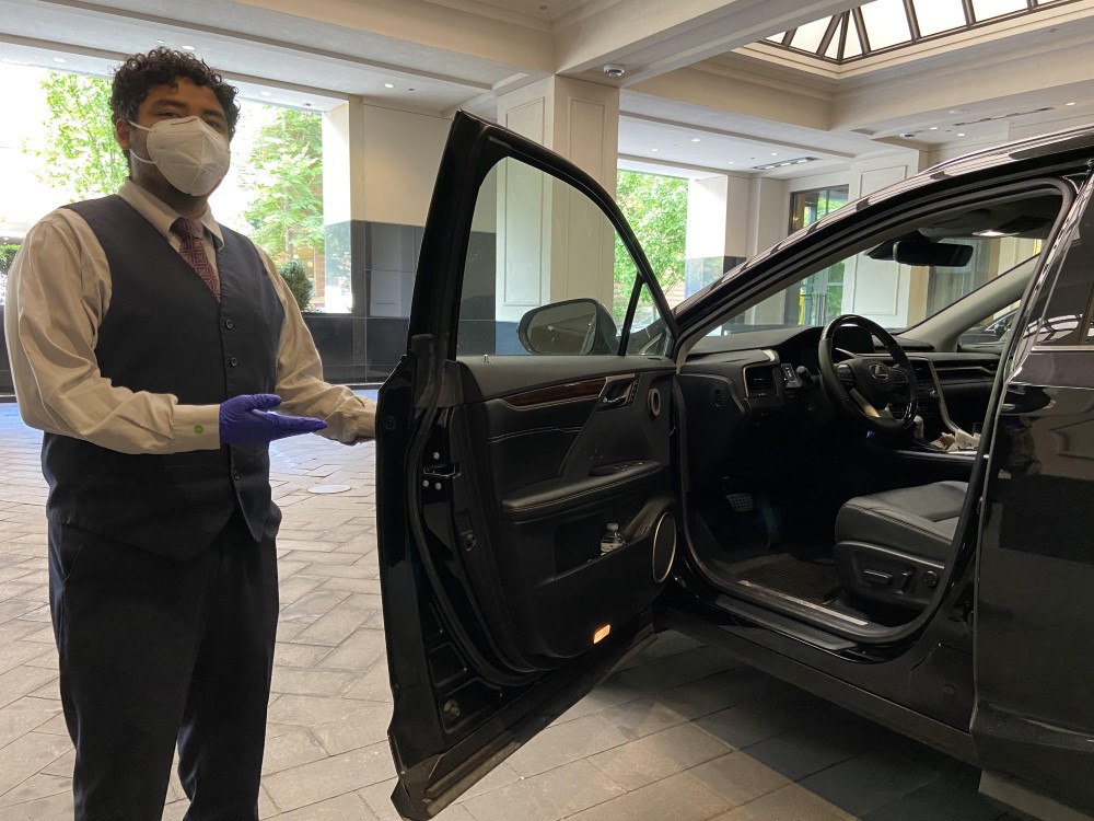 Hospital valet staff assisting patients at a well-organized healthcare parking entrance.