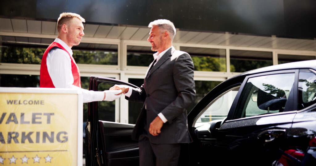 Hotel valet attendant managing parking revenue optimization at a luxury property entrance